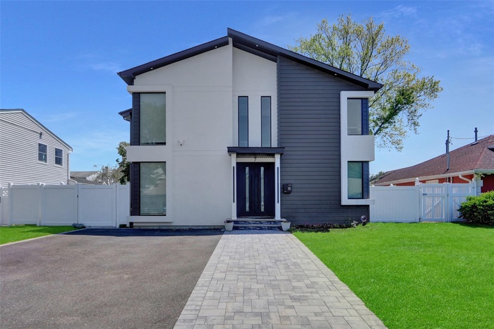 Contemporary house featuring a gate, stucco siding, and a patio area