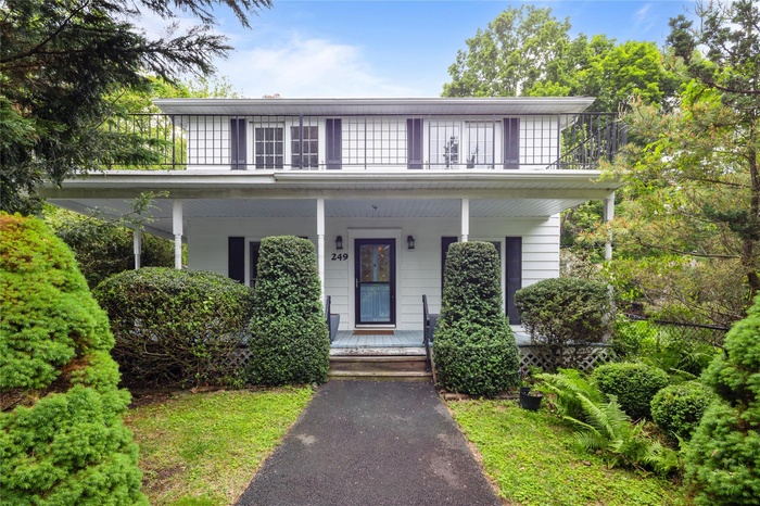 View of front of home featuring covered porch and a balcony