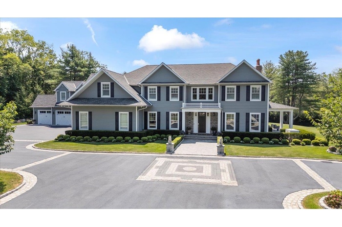 View of front of property featuring a front lawn, a chimney, a porch, and uncovered parking