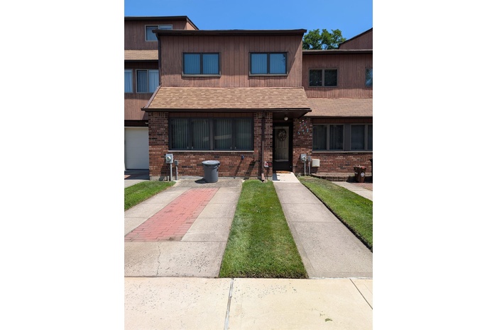 View of front of home with brick siding and a shingled roof
