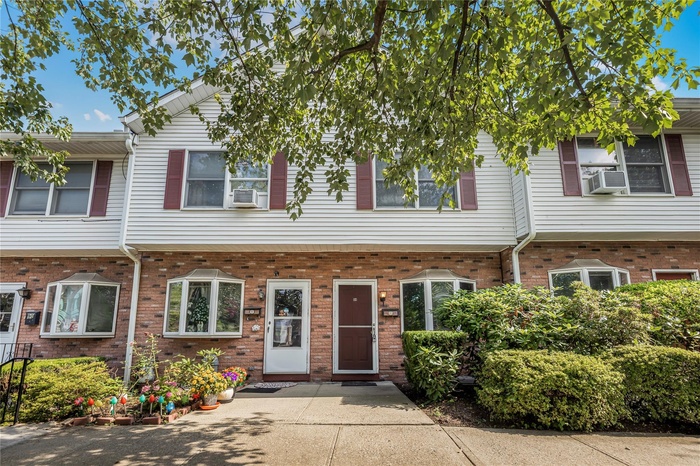 Colonial home featuring brick siding