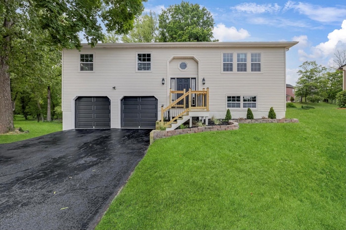 Bi-level home with a garage, driveway, and a front lawn