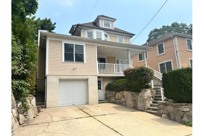 View of front facade with stairway, a garage, concrete driveway, and stucco siding