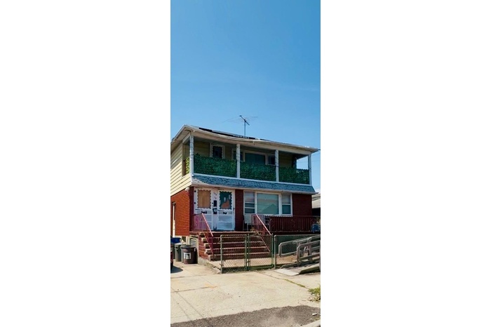 View of front of home featuring a fenced front yard and brick siding