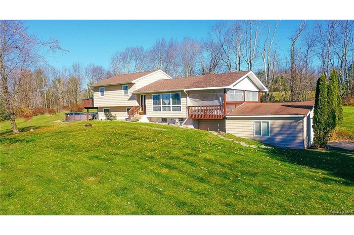 Rear view of property with a sunroom and a lawn