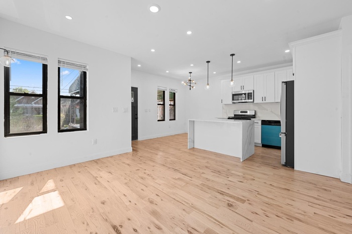 Kitchen with open floor plan, light wood-style floors, recessed lighting, a chandelier, and appliances with stainless steel finishes