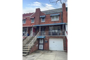This is a 2 story attached 2 family brick home with an attached garage.