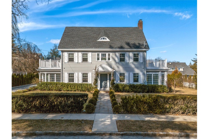 View of front of property featuring a balcony and a chimney