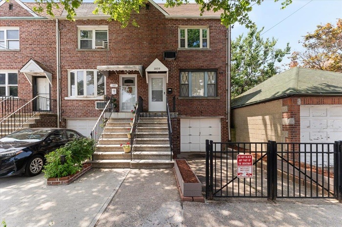 Single family property with a garage, brick siding, and a gate