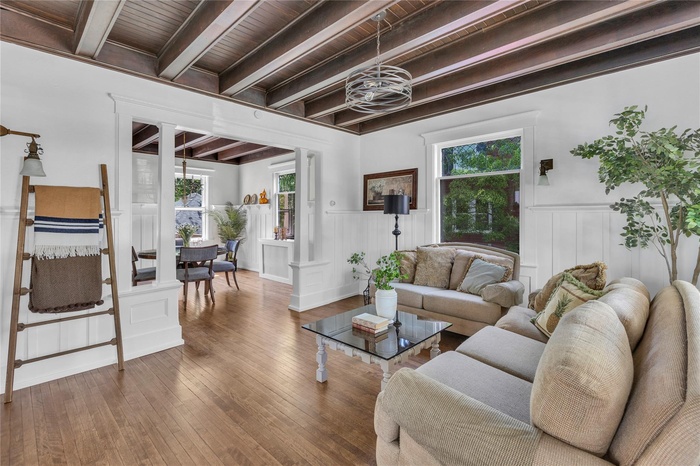 Victorian style home featuring a porch, a front yard, a shingled roof, and a chimney