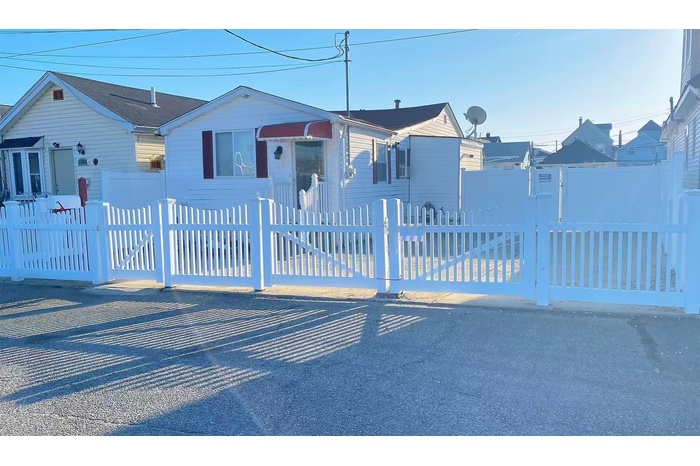 Bungalow-style house featuring a fenced front yard and a gate