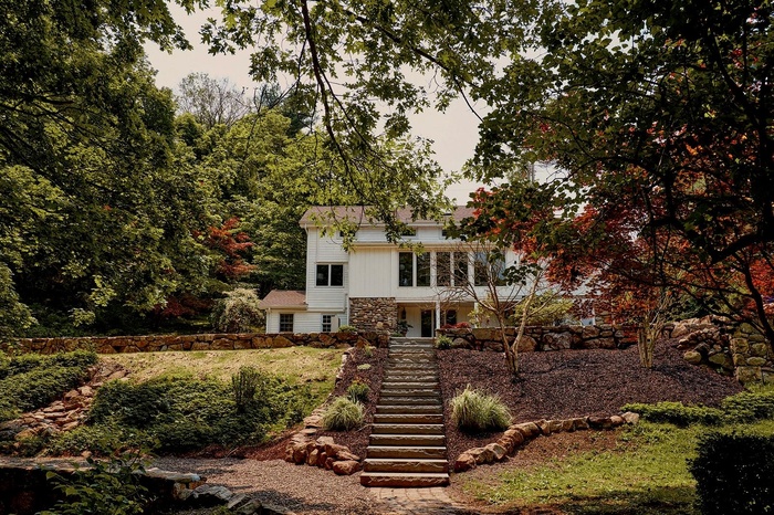 View of front of home with stairs and stone siding
