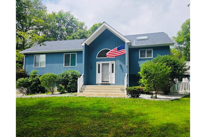 View of front of house featuring a front yard and a shingled roof