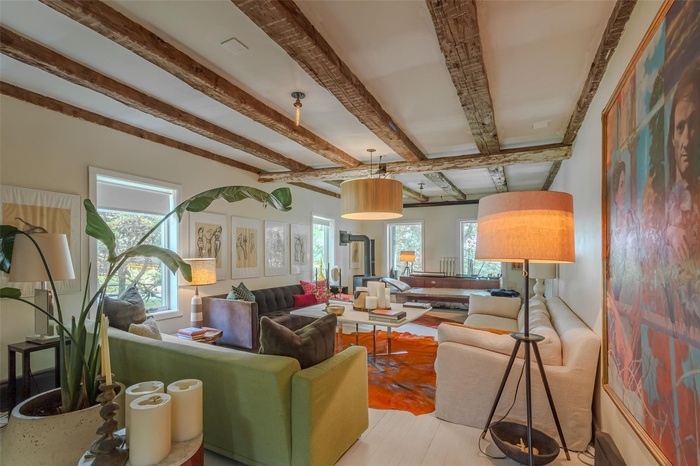 Living room with beam ceiling, healthy amount of natural light, and wood finished floors