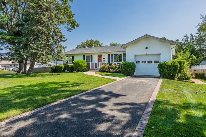 Single story home featuring a garage and asphalt driveway