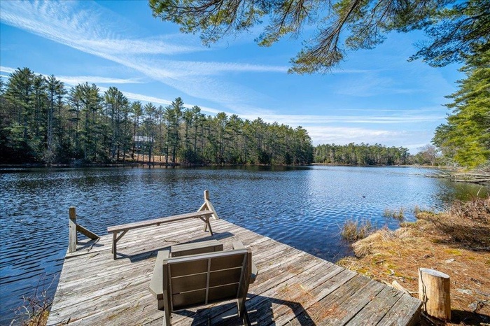 Dock area featuring a water view and a forest view