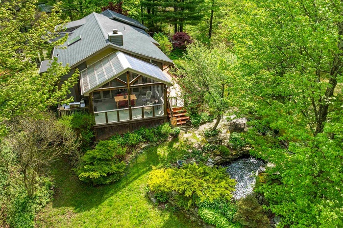 View from above of property featuring a screened in porch and water feature.