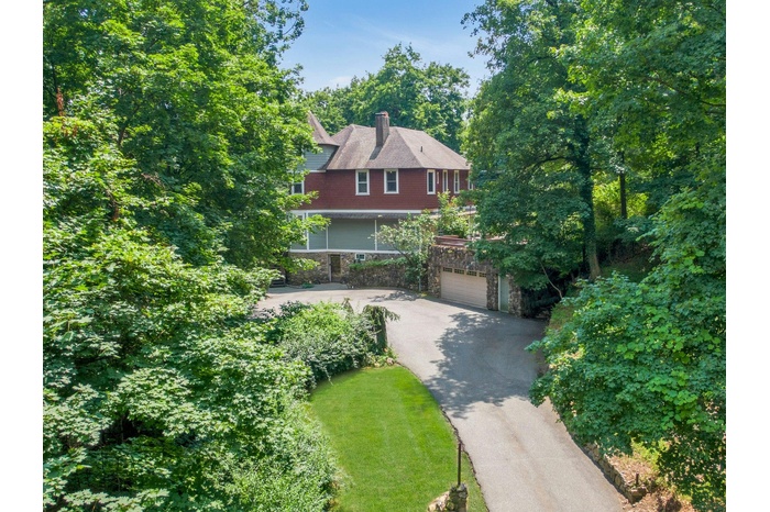 View of front of property featuring stone siding, driveway