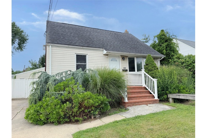 View of front of property featuring roof with shingles and a chimney