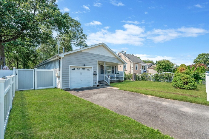 View of front facade featuring a porch, an attached garage, and driveway