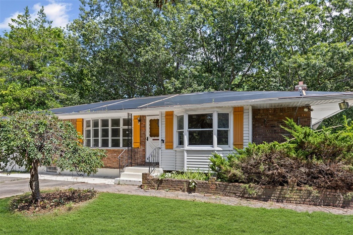 View of front of house featuring brick siding and a front yard