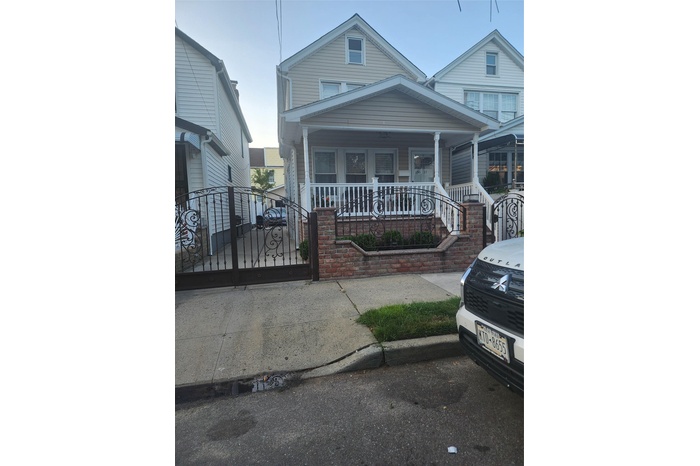 View of front of property with a porch, a gate, and a fenced front yard