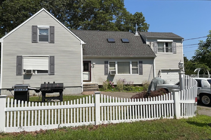 Traditional-style home featuring a shingled roof and an attached garage