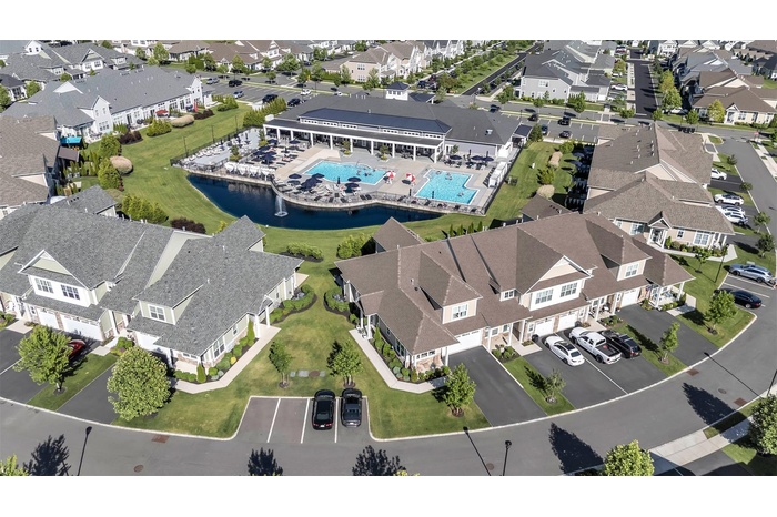 Aerial view of property's location with views of the Pond with fountain, two Pools and Clubhouse