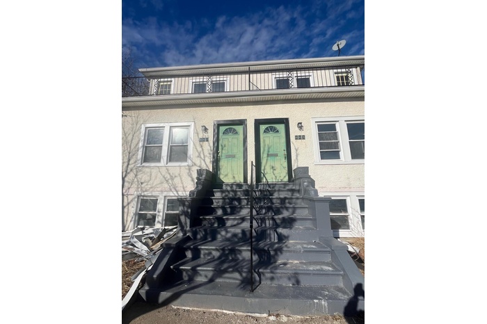Entrance to property with stucco siding and a balcony