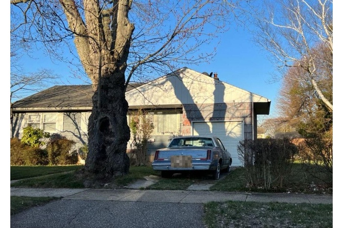 View of side of property featuring an attached garage and driveway