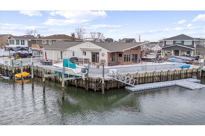 View of dock with a residential view, a water view, and a fenced backyard