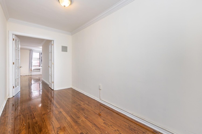 Entry room with crown molding and wood finished floors