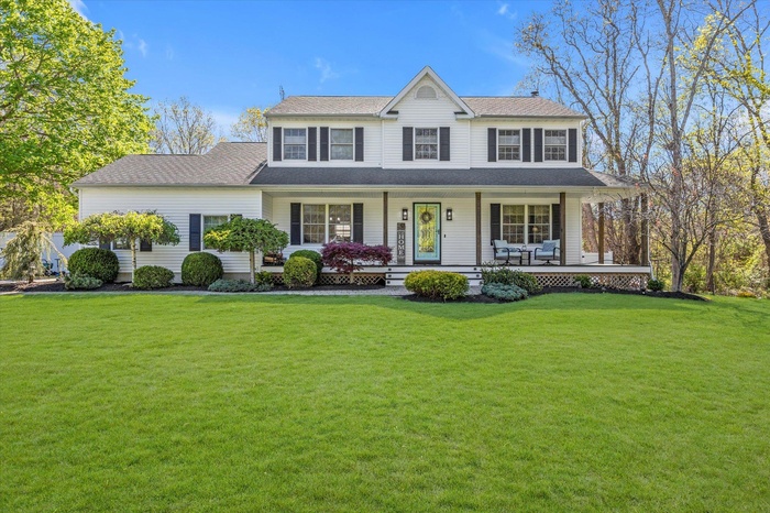 View of front of home with covered porch and a front yard