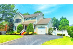Charming 3BR Home with Garden Oasis Near the LIE This beautiful single family home features a welcoming front porch, lush manicured gardens, and mature trees.