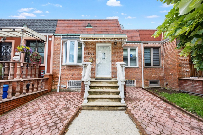 View of front of property featuring brick siding and mansard roof