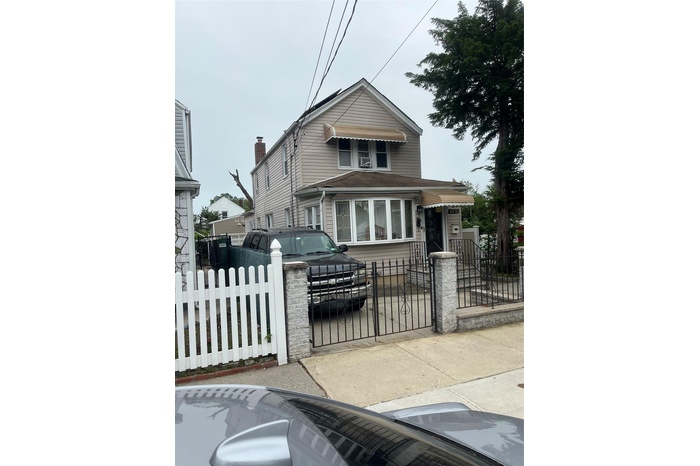 View of front facade featuring a fenced front yard and a gate