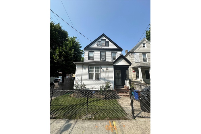 View of front of home featuring a fenced front yard and a gate