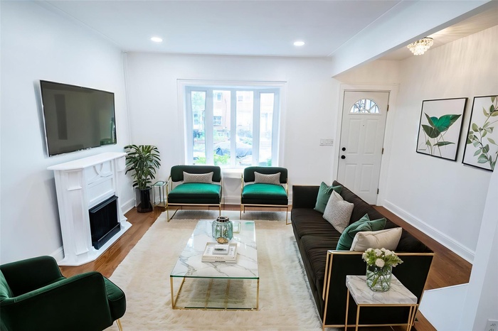 Living room featuring wood finished floors, a fireplace, and recessed lighting