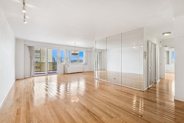 Unfurnished living room with light wood-style floors, rail lighting, and a chandelier