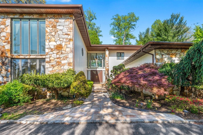 View of front of house with stone siding, circular drive way