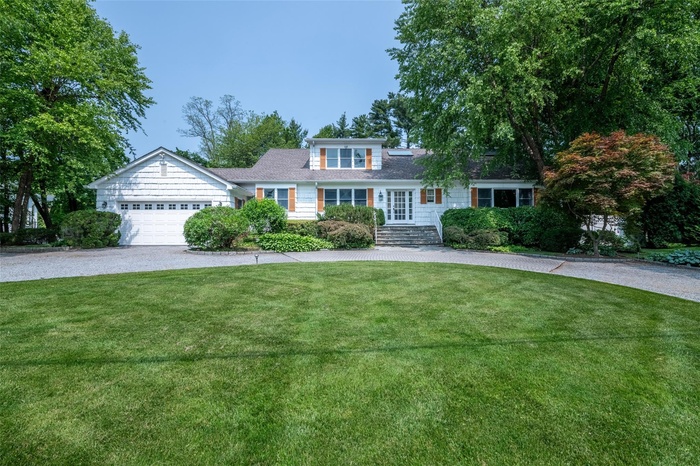 Welcome to 25 Old Lyme Road. This is a shingle-style home with a circular driveway, a front yard, and an attached 2-car garage
