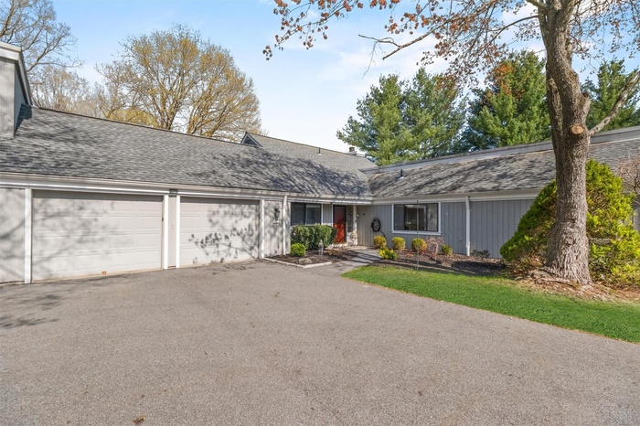 View of front of home featuring driveway, an attached garage, and a shingled roof