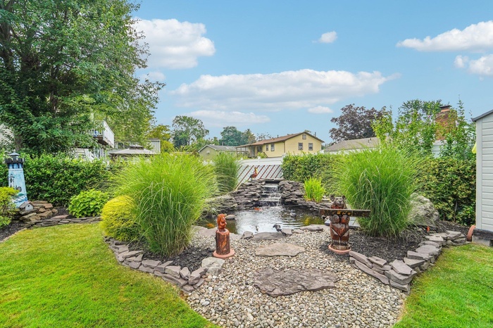 View of grassy yard with a garden pond