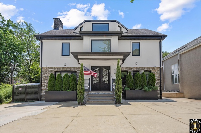 View of front facade featuring stone siding, stucco siding, a chimney, and entry steps