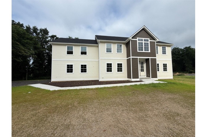 Rear view of house featuring a lawn and board and batten siding