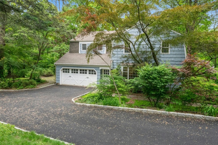 View of front of home with a 2-car garage attached, new paved driveway edged with Belgium blocks driveway,