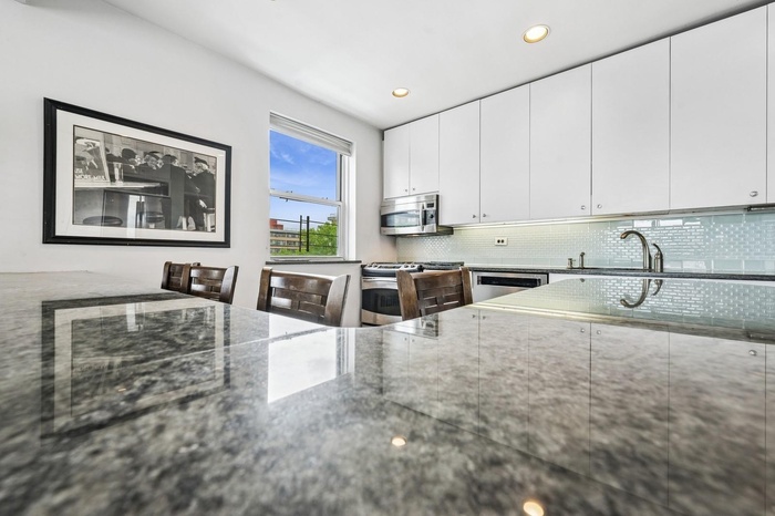 Kitchen featuring appliances with stainless steel finishes, a sink, tasteful backsplash, dark stone countertops, and recessed lighting