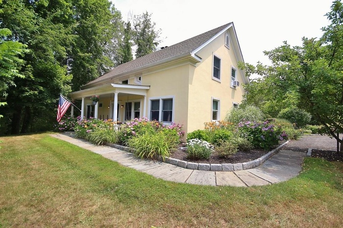 Front Exterior featuring a lawn and covered porch