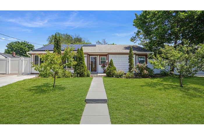 View of front of property with solar panels and a gate