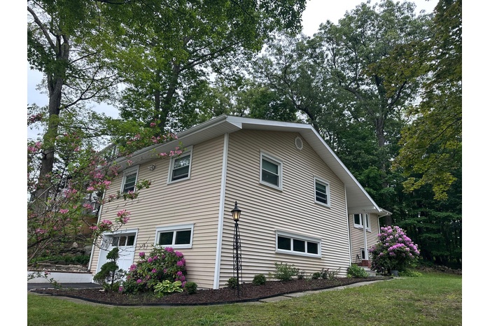 View of side of property with a lawn